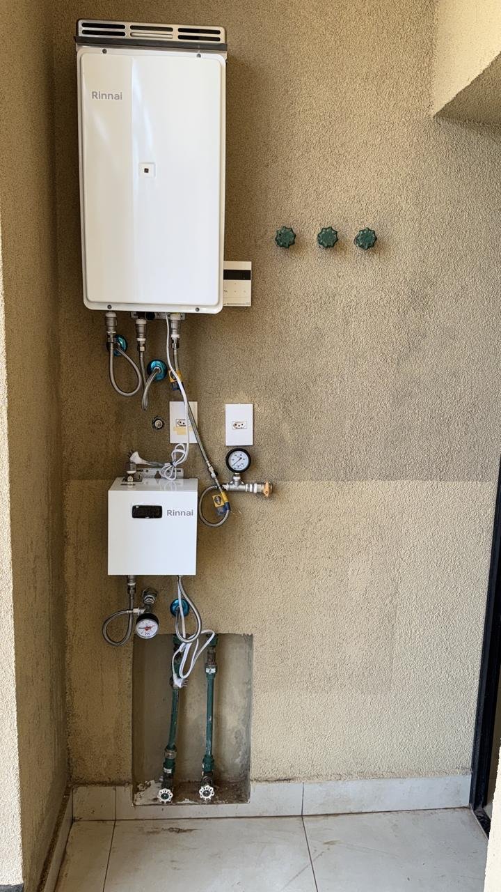 Aquecedor de água a gás e pressurizador Rinnai instalados em parede de área externa